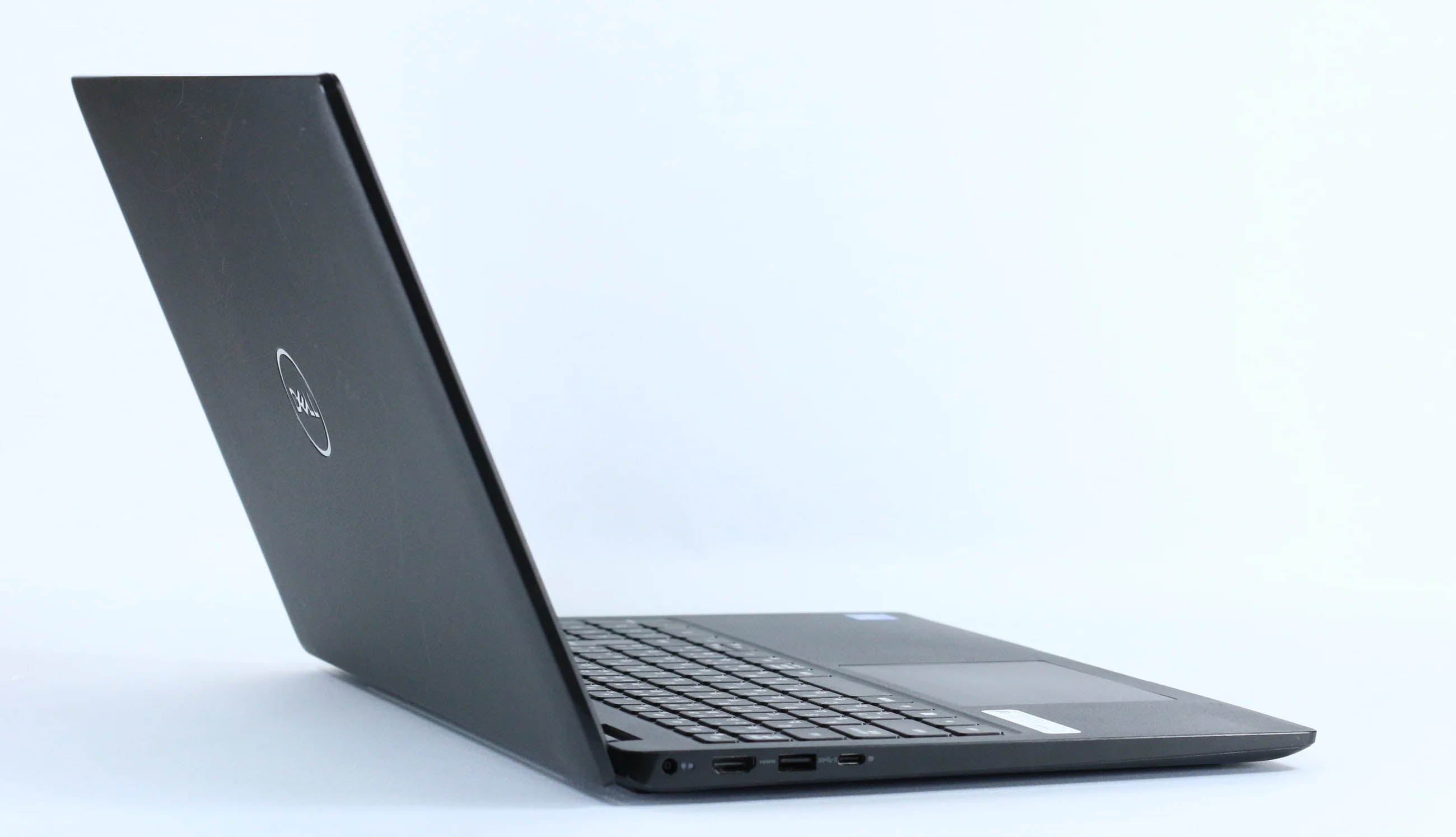 斜め横から見た黒のDell Latitude 3520ノートパソコン、ロゴと側面ポートが映る開いた状態